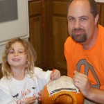 dad and nik carving pumpkin